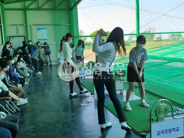 -사진설명 _김자영 프로가 학생에게 스윙폼을 지도하는 모습